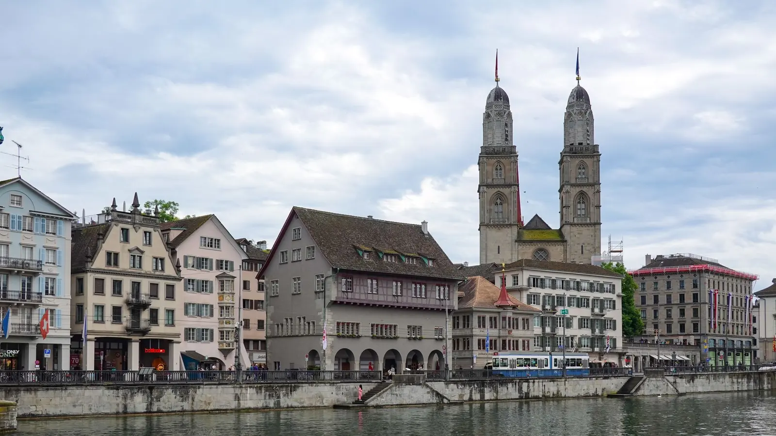 Historic waterfront buildings and church towers beside a river in Zurich